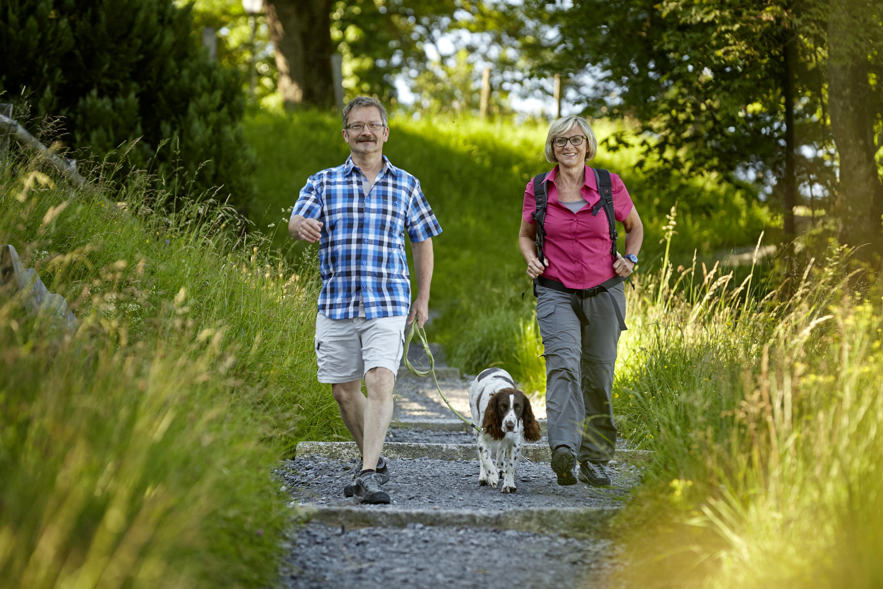 Zwei ältere Menschen mit Hund am wandern
