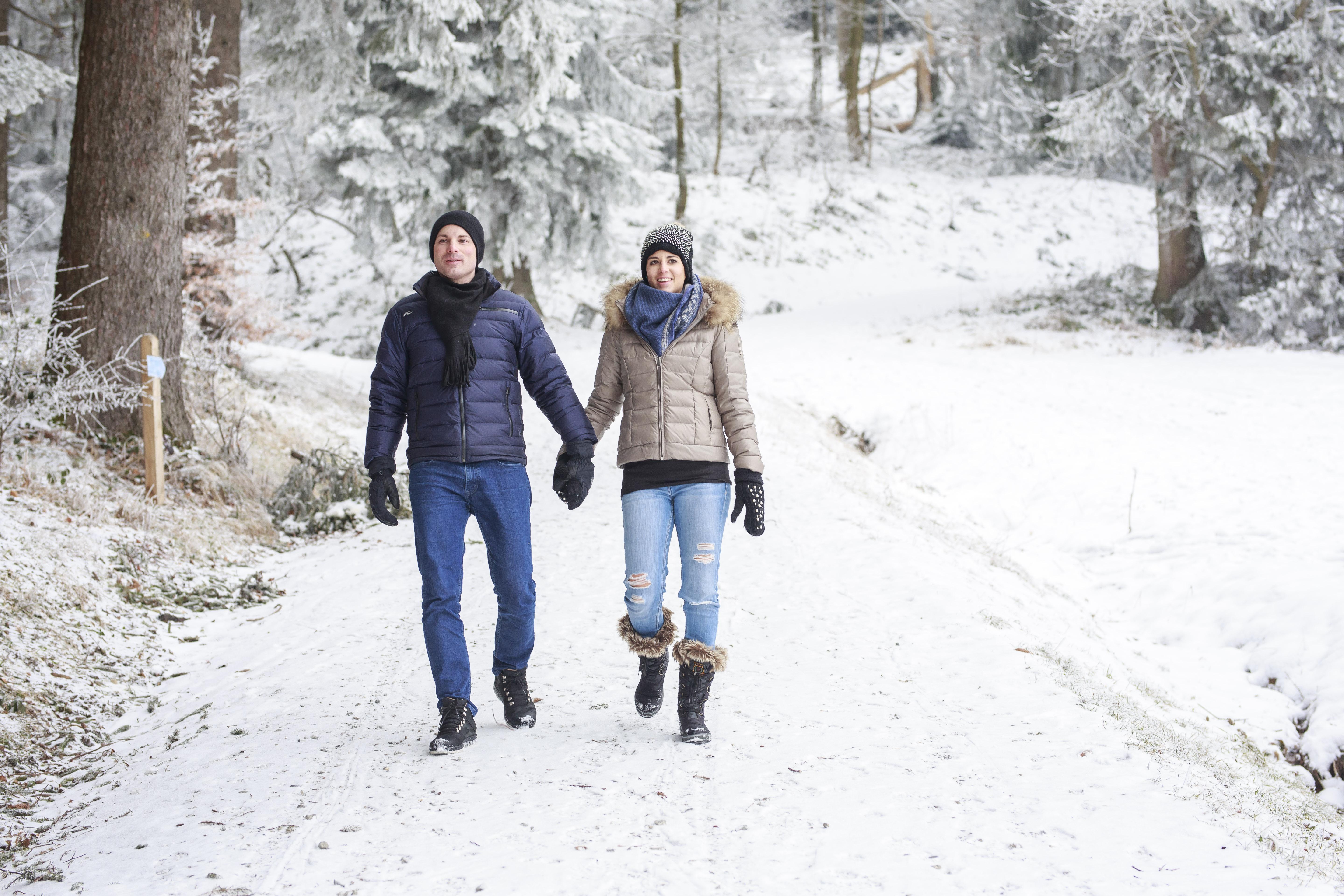 Zwei Personen in einem verschneiten Wald am spazieren